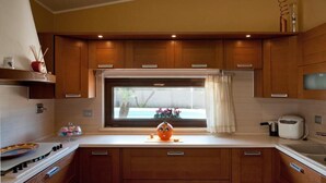 Una cocina moderna con armarios de madera, una ventana con vistas, una estufa y un tostador.