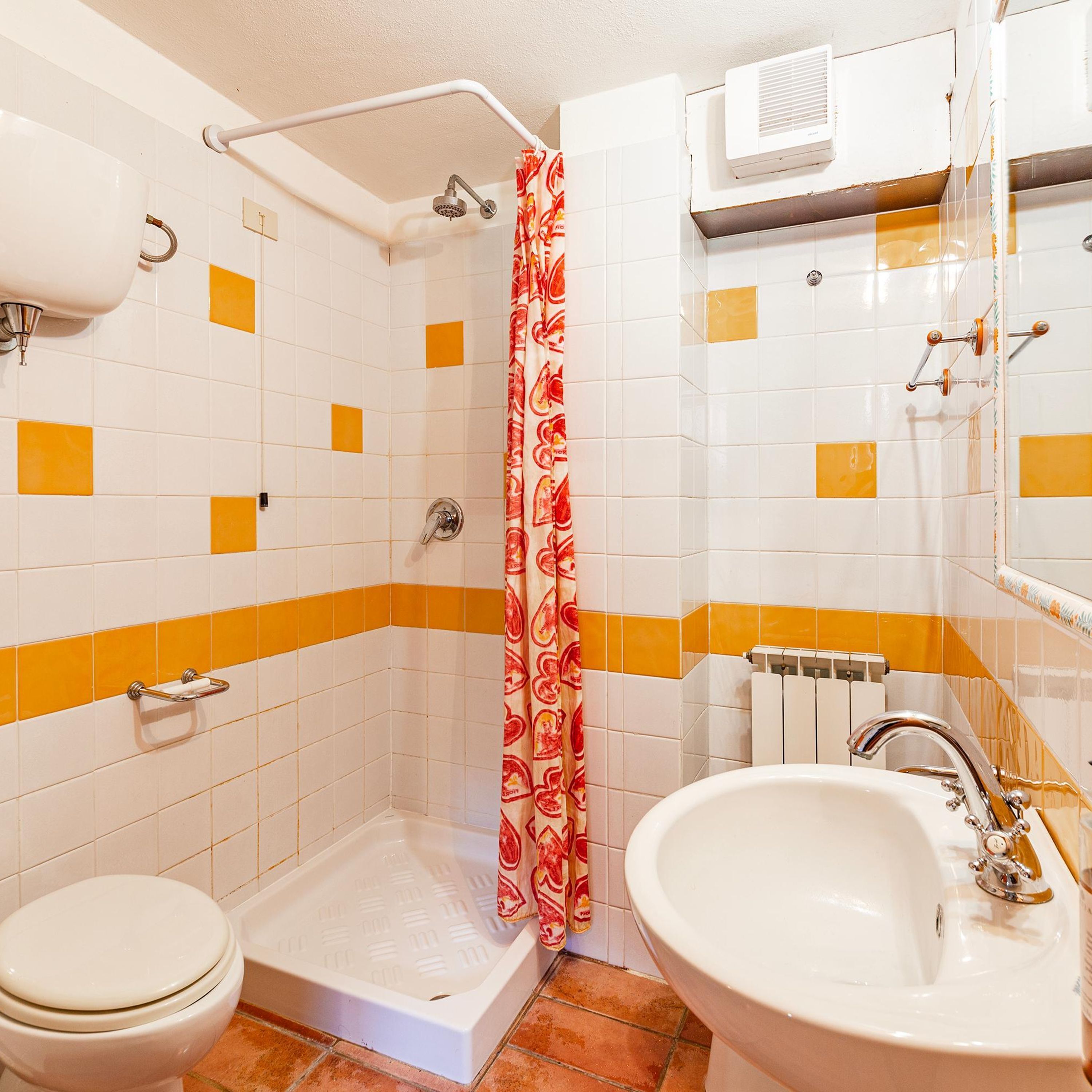 A bathroom with a shower, toilet, and sink.