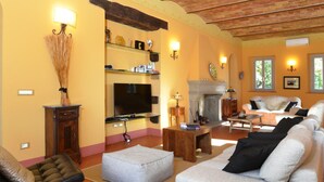 Un salon chaleureux avec une cheminée, des fauteuils confortables et un téléviseur.