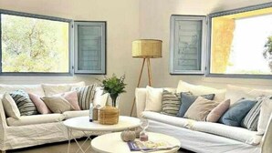 Un salon avec deux canapés blancs, une table basse ronde et un lampadaire.