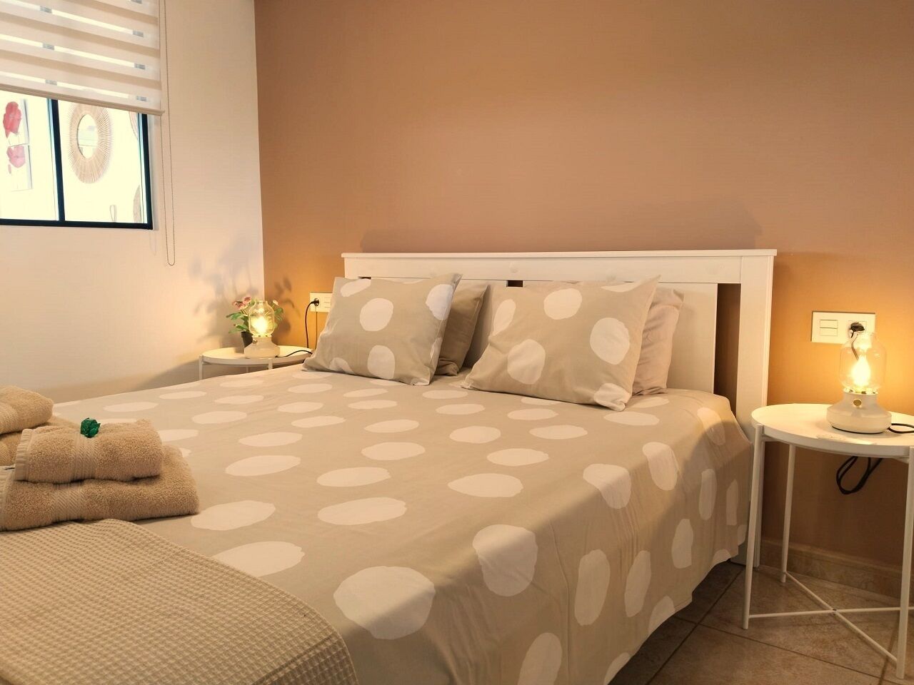 Ein Schlafzimmer mit einem Bett, zwei Nachttischen und einem Beistelltisch.