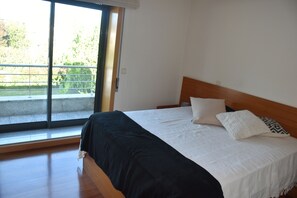 Une chambre à coucher avec un lit, une fenêtre et un balcon.