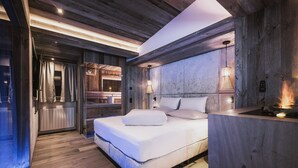 Une chambre moderne avec un plafond en bois, un grand lit et un banc intégré.