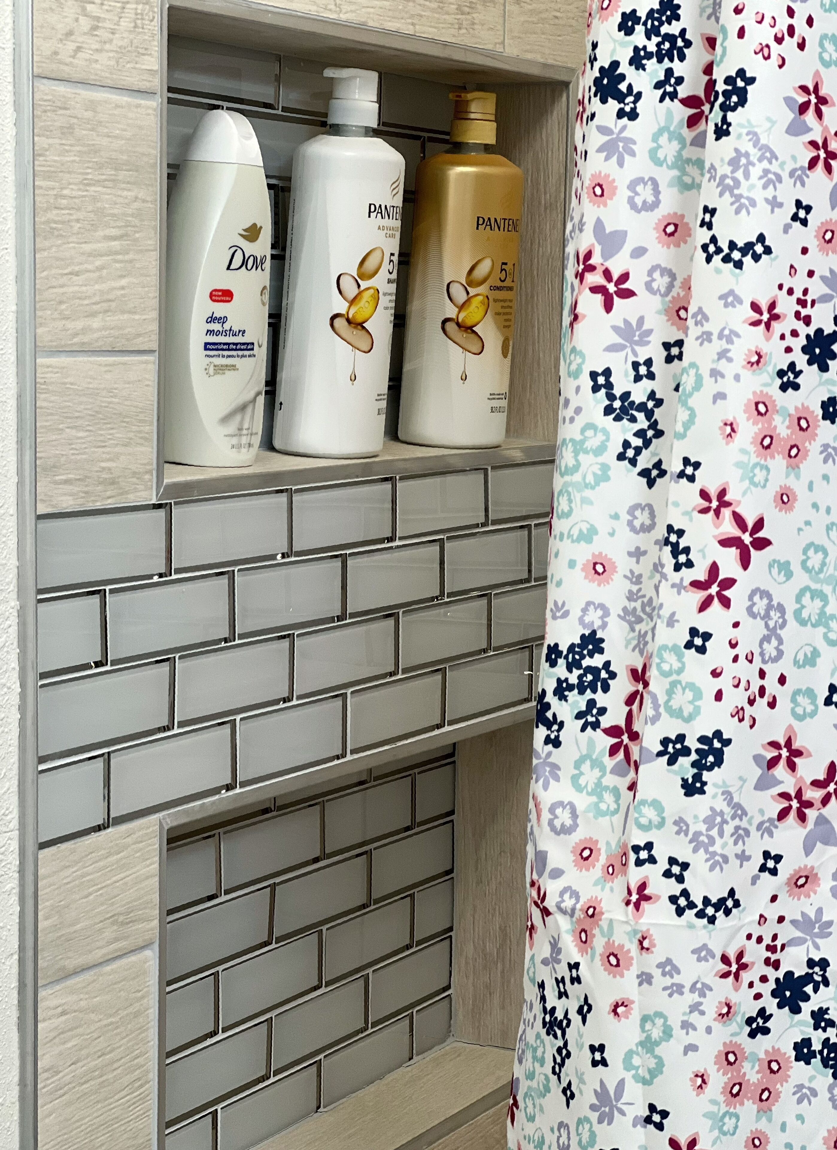 A bathroom shelf with three Pantene hair care products.