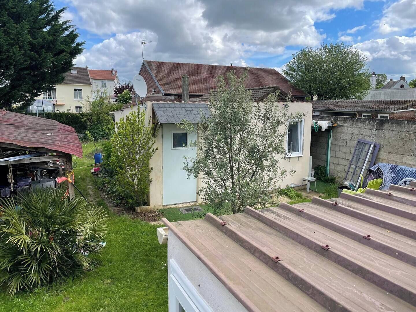 Ein Wohngebiet mit einem kleinen Haus, einer Garage und einem Garten.