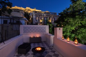 A rooftop terrace with a checkered floor, a small table with candles, and a view of historic buildings in the background. - Muazzo Plaka Upper Home, Views to Acropolis (Athina)