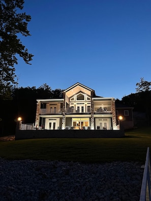 A two-story house with a balcony, a garage, and a well-lit front entrance.