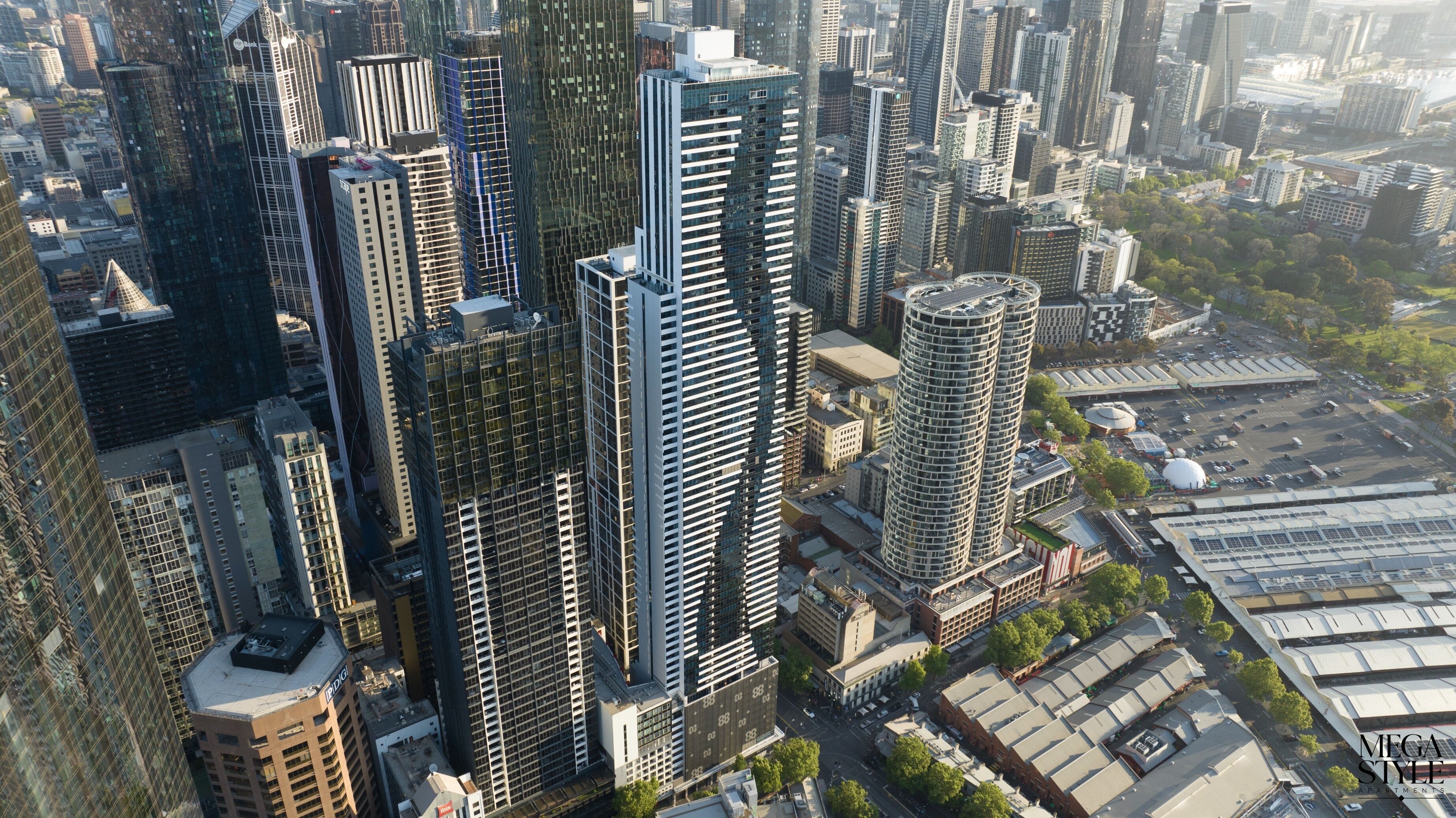 A high-rise building with a modern architectural design, featuring a grid-like facade and multiple balconies.