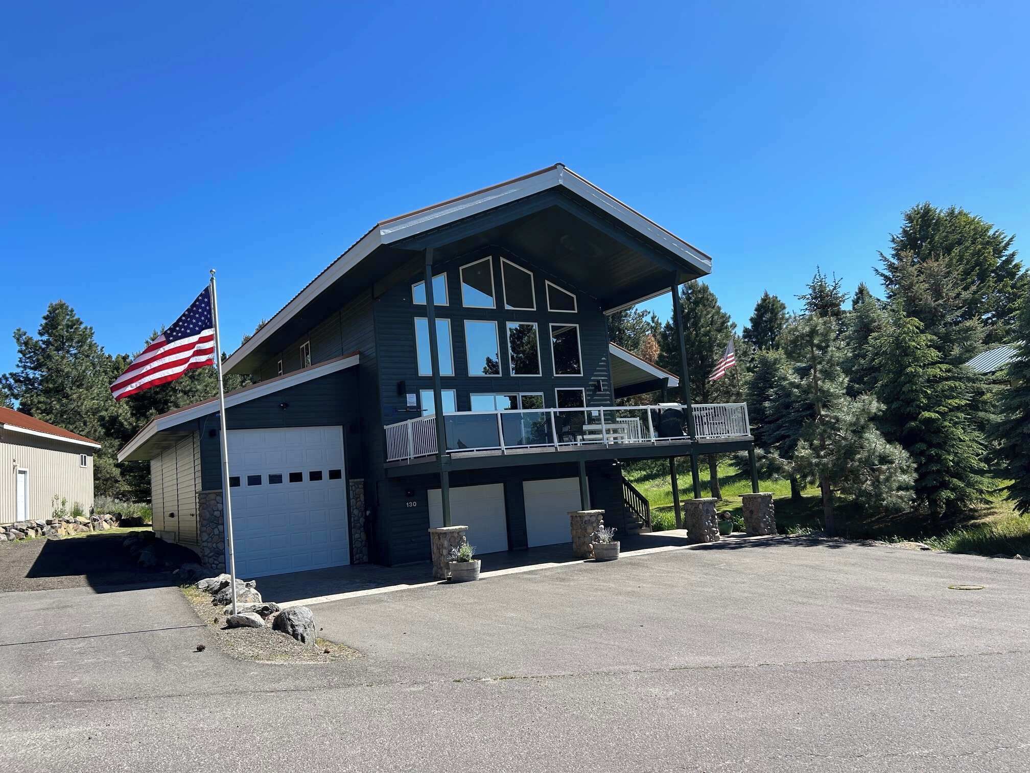 A two-story house with a garage, a balcony, and an American flag.
