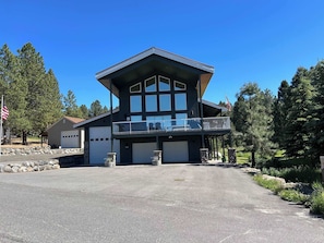A two-story building with a balcony, a garage, and a flag. - Lake House In Cascade w/ Hot Tub (Cascade)