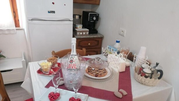 A dining table set with various dishes, a bottle, and heart-shaped decorations, indicating a special occasion. - La Casetta di Mimmi (Castel Viscardo)