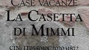 A sign for "Case Vacanze La Casetta di Mimmi" with a metal plaque and a clear plastic cover. - La Casetta di Mimmi (Castel Viscardo)