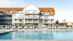 A hotel with a swimming pool, multiple balconies, and a tiled roof. - Evancy Trésors d'Opale (Camiers)
