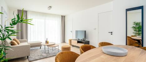 Una sala de estar moderna con un sofá, una mesa de centro y una mesa de comedor.