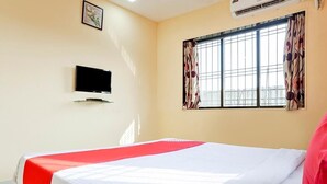 A hotel room with a bed, a flat-screen TV mounted on the wall, and a window with curtains. -  Royal Hills Resort (Mawal)