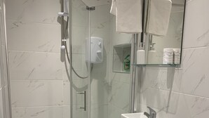 A modern bathroom with a glass-enclosed shower, a white sink, and a toilet. - Wagtail Way Kent (Orpington)