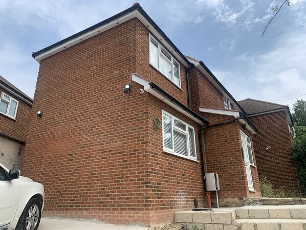A two-story brick house with a white car parked in front. - Wagtail Way Kent (Orpington)