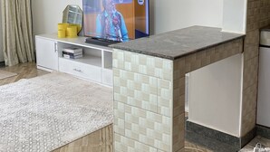 Un soggiorno moderno con televisione, un tavolino e un divano.