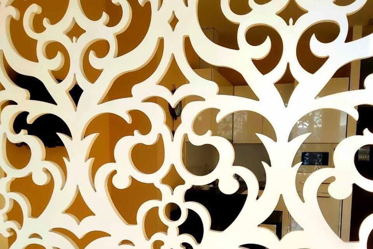 A decorative white panel with intricate cut-out patterns.