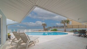 A pool area with lounge chairs and a view of the ocean. - Ponce Inlet Beach House (Ponce Inlet)