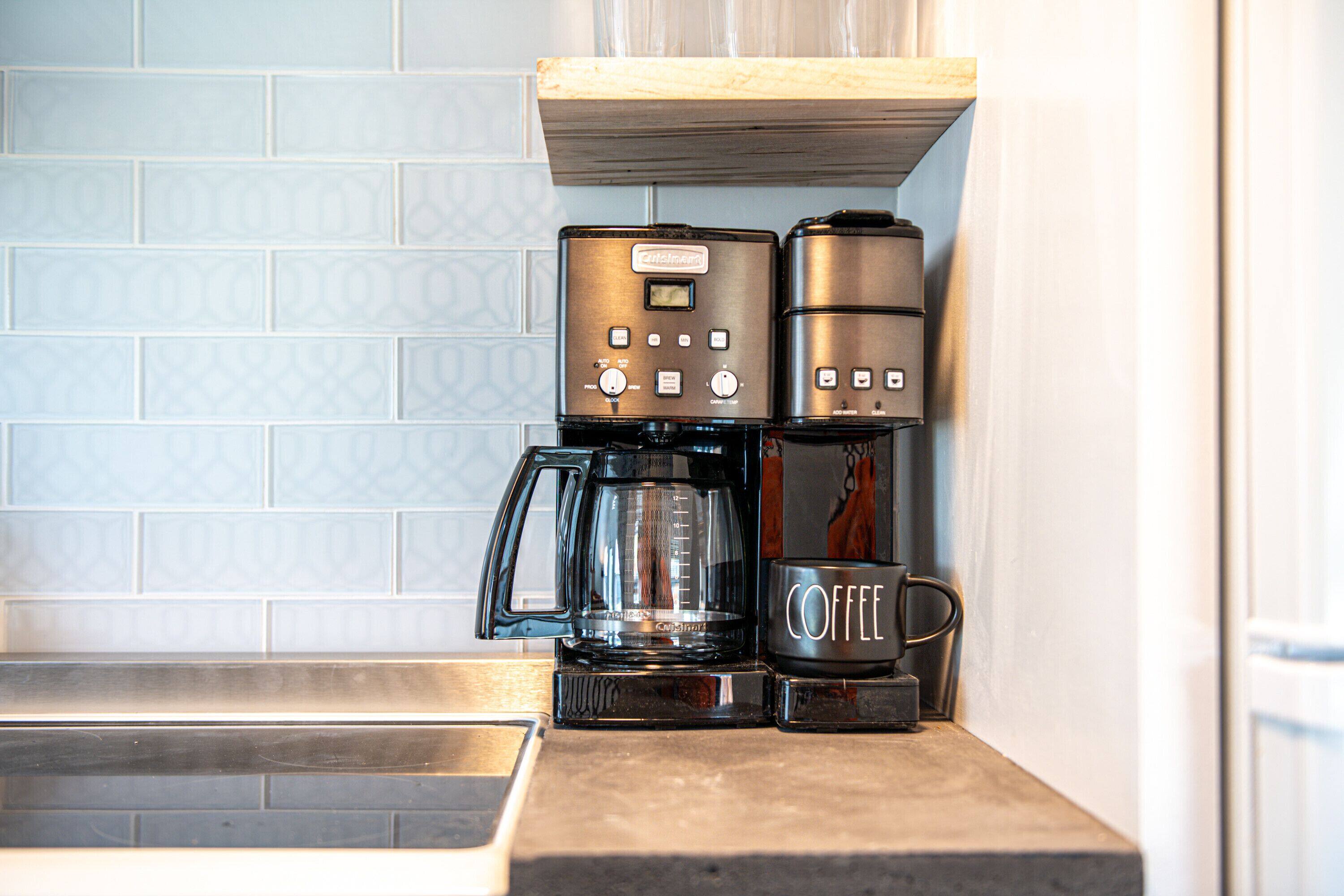 Una cucina con una macchina da caffè e una caffettiera sul piano di lavoro.