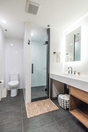A modern bathroom with a glass-enclosed shower, a white sink, and a large mirror. - This serviced apartment is a 2 bedroom(s), 2 bathrooms, located in Lexington, KY. (Lexington)