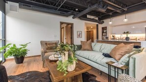 Un salon moderne avec un canapé vert clair, une table basse en bois et un fauteuil à motifs léopard.