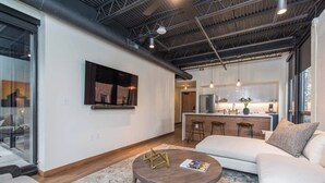 A modern living room with a sofa, a coffee table, and a kitchen area in the background. - This serviced apartment is a 1 bedroom(s), 1 bathrooms, located in Lexington, KY. (Lexington)