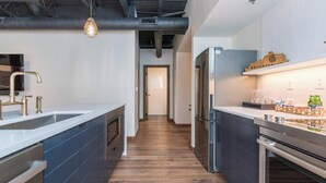 A modern kitchen with a central island, stainless steel appliances, and a wooden floor. - This serviced apartment is a 1 bedroom(s), 1 bathrooms, located in Lexington, KY. (Lexington)