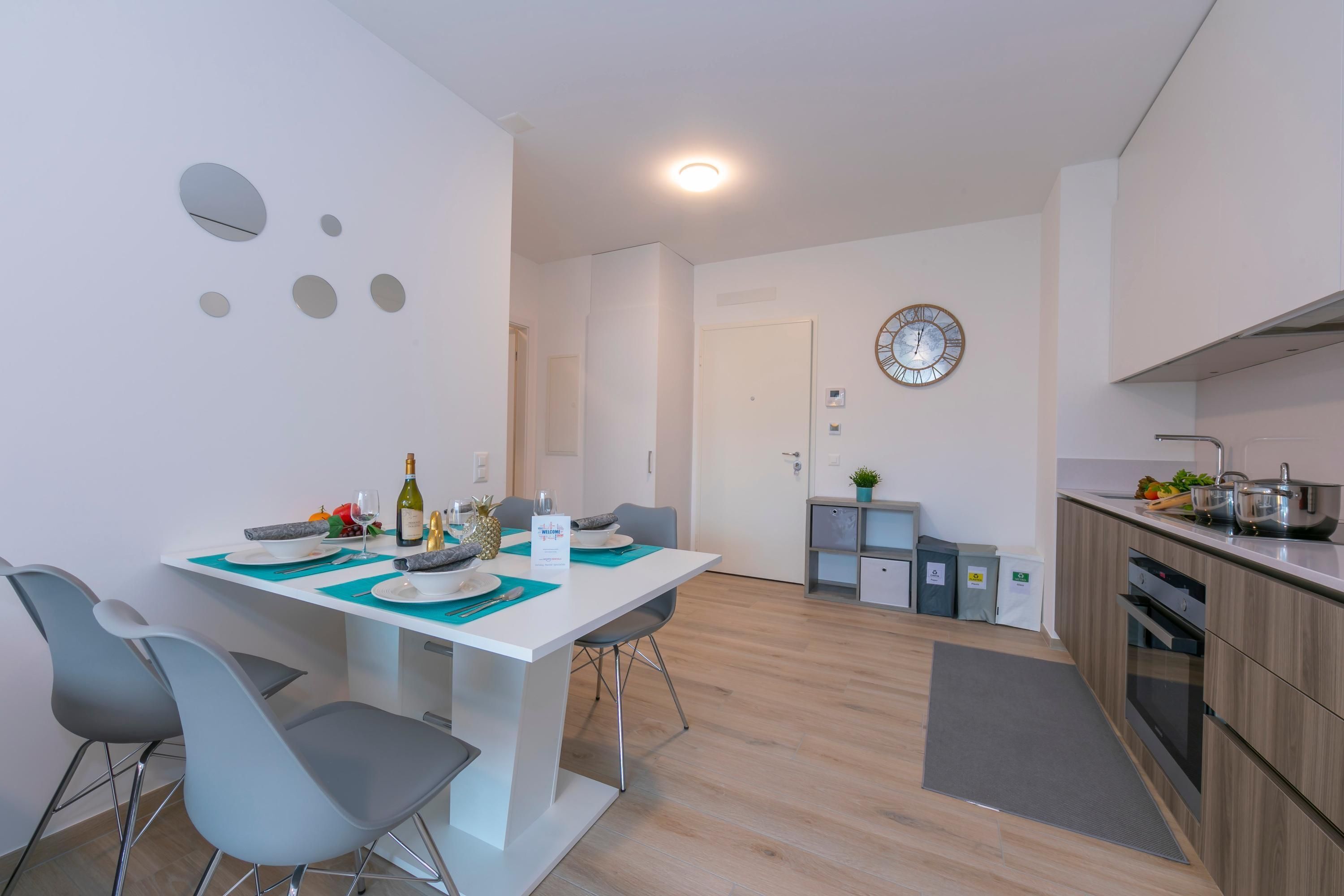 A modern kitchen with wooden cabinets, a built-in oven, and a sink.