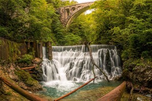 A waterfall with a stone bridge in the background. - Chalet Kupljenik Near Bled Lake (Bled)