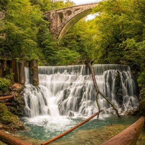 A waterfall with a stone bridge in the background. - Chalet Kupljenik Near Bled Lake (Bled)