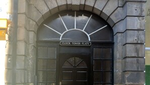 A black door with a sign above it reading "CLOCK TOWER FLATS". - Clock Tower Flats Morpeth (Morpeth)