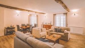 A living room with a sofa, armchairs, a dining table, and a coffee table. - Douro Mool Guest House (Lamego)