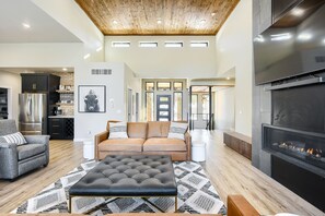 A spacious living area with a modern fireplace, a sofa, and a dining area. - Luxurious One-Of-A-Kind 4900+ Sq. Ft. Access to Clubhouse Pools! Parking! (Lead)
