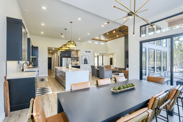 A spacious kitchen with a central island, a dining area with a large table, and a living area with a sofa and chairs. - Luxurious One-Of-A-Kind 4900+ Sq. Ft. Access to Clubhouse Pools! Parking! (Lead)