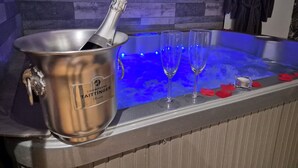 Un mini-bar comprenant une bouteille de champagne, deux verres et un petit récipient, le tout posé sur le comptoir du bar.