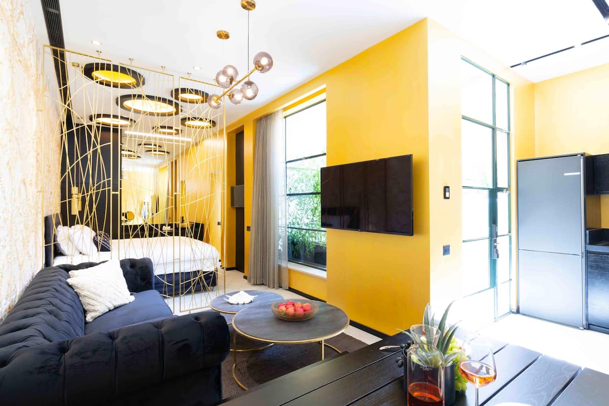 A modern living room with a sofa, a round coffee table, and a TV mounted on the wall.