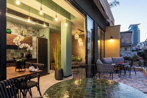 A modern kitchen with a dining area, a large potted plant, and a patio with outdoor seating. - The Shell House (Tel Aviv)