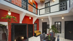 A multi-level interior with a central seating area, black and white patterned flooring, and decorative lighting fixtures. - Riad Mylaya (Marrakech)