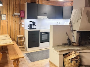 Eine gemütliche Küche mit Holzwänden, einem Herd und einem Kamin.