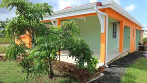 A house with a porch, a small garden, and a tree. - House well located in La Jaille in the center of Guadeloupe (Baie-Mahault)