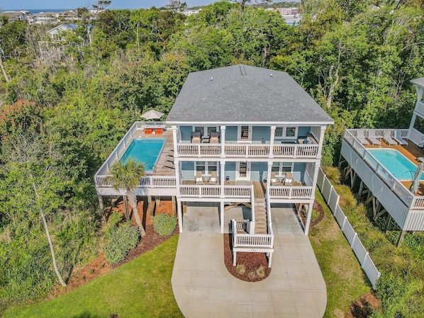 Enjoy the serene views from multiple balconies overlooking lush greenery and a swimming pool.