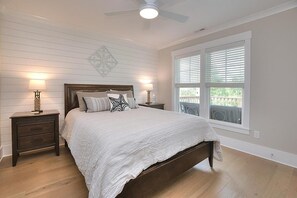 Relax in this serene bedroom with a large bed, two nightstands, and a ceiling fan.