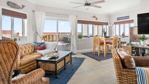 A spacious living room with a large window, a ceiling fan, and a dining area with a view. - ** Prices dropped $300 per week, for all remaining 2023 weeks. Prices shown include the discount. **<br>Avalon Penthouse 803 - 1 of a kind 3 br/3 bath with huge balcony and incredible views. (Ocean City)