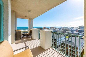 A balcony with a view of the ocean and cityscape.