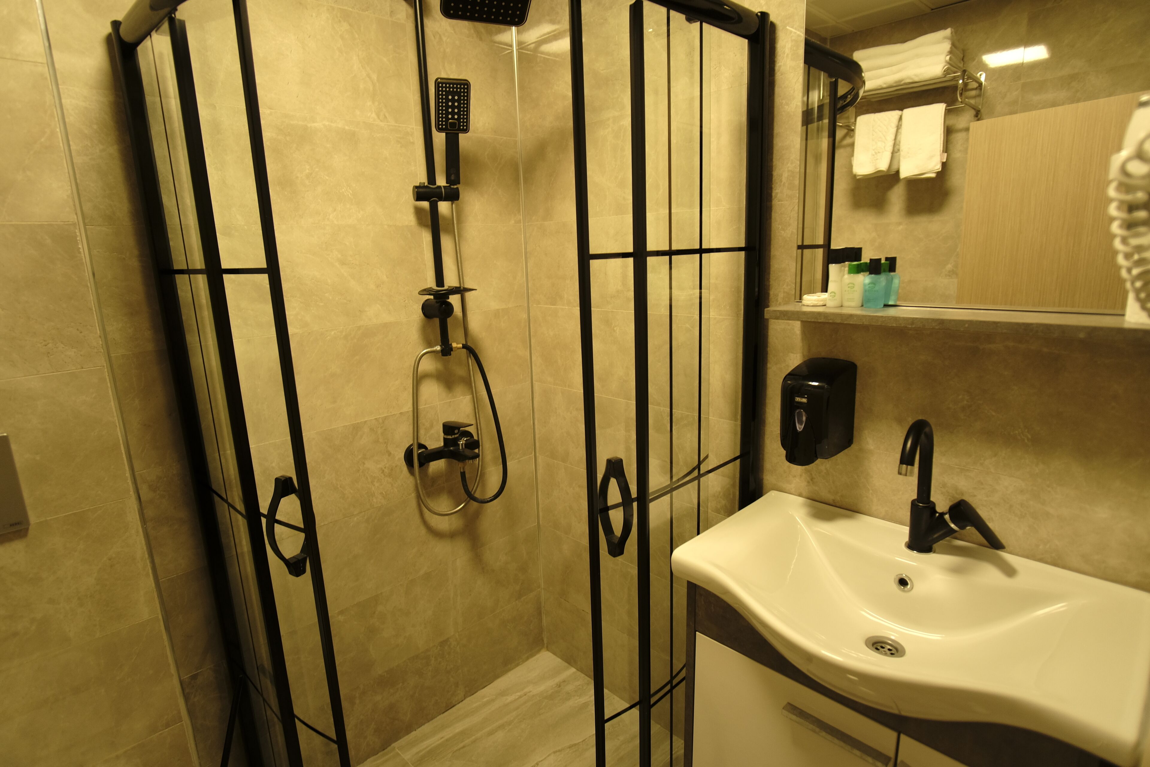 Un baño con ducha, lavabo y espejo.