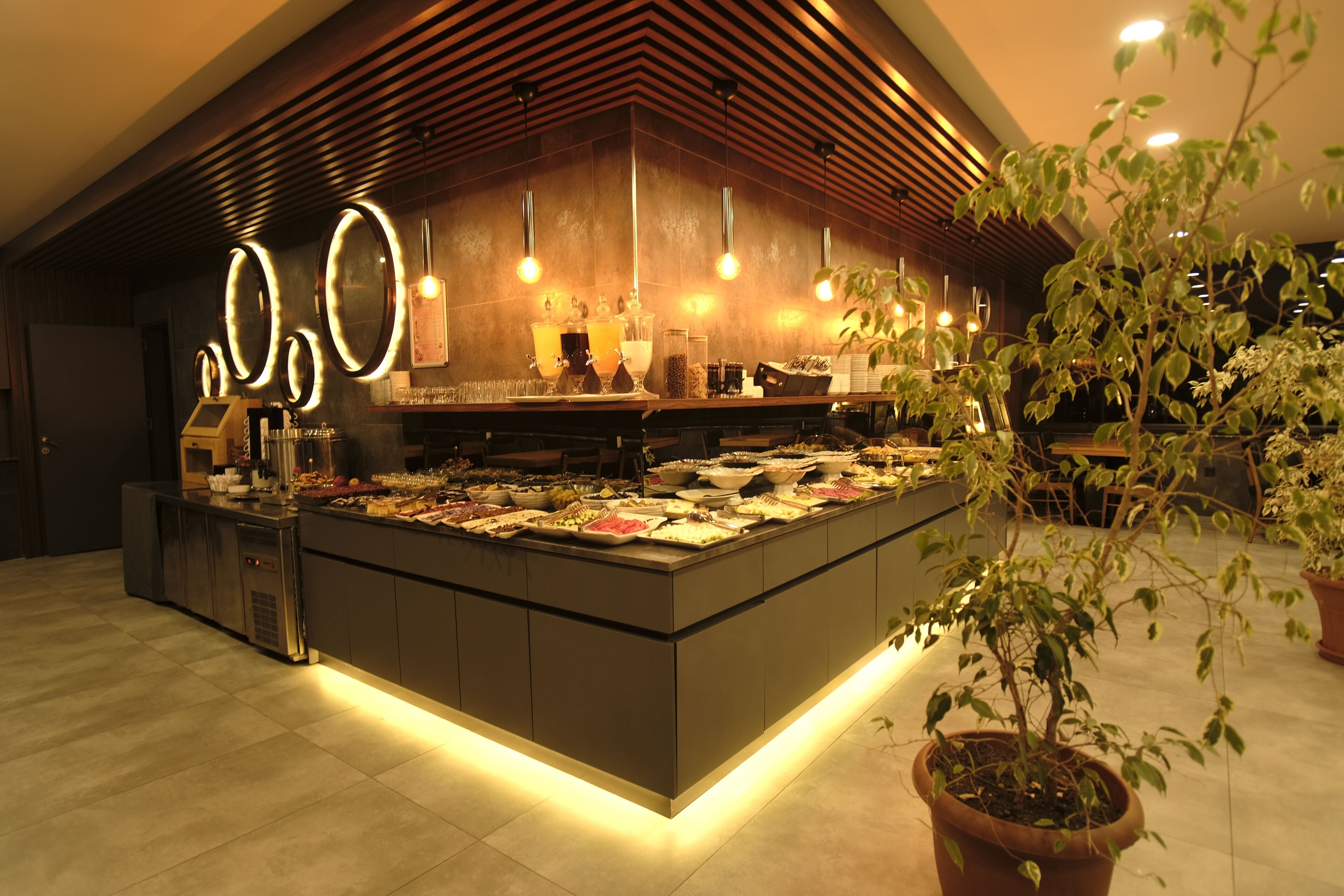 A modern bar area with a central island displaying various food items and a bar counter.