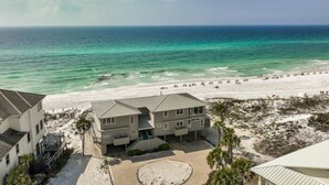 A beachfront property with a large sandy beach, a clear view of the ocean, and a building with multiple floors and balconies. - Gulf-Front with Private Deck and Water Views (Miramar Beach)