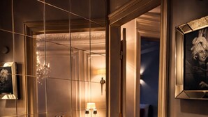 A room with a wooden floor, a sofa, a lamp, and a radiator. - Sleephotels Alsterroom (Hamburg)